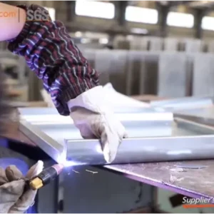 Worker welding metal letters at signage manufacturing plant