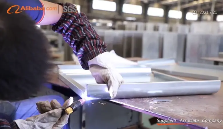 Worker welding metal letters at signage manufacturing plant