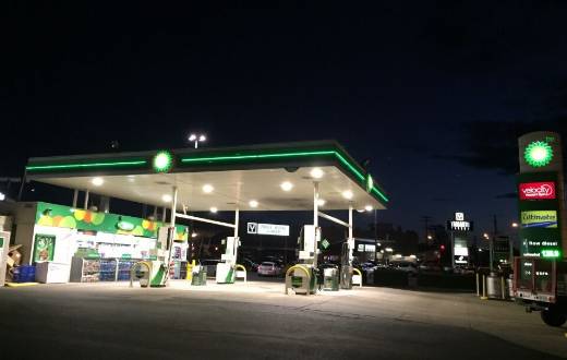 Illuminated LED gas station sign for BP featuring digital price changers and video wall