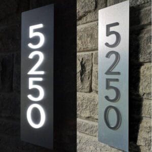 Custom backlit LED house number factory product showing illuminated 5250 vertical address sign on stone wall