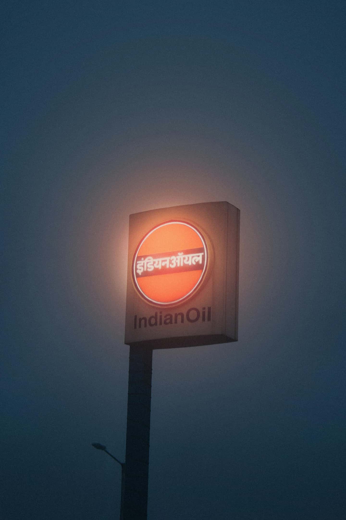 Gas station pole sign at foggy night